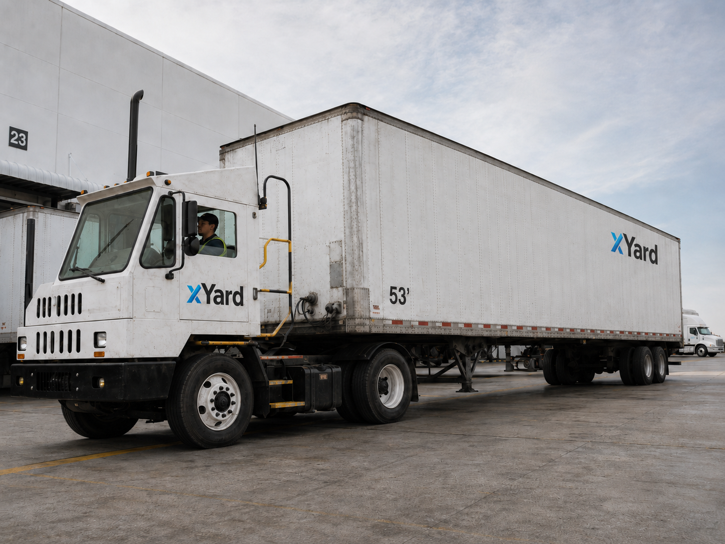xYard hostler truck moving a trailer at a warehouse dock